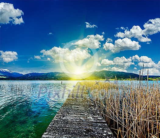Pier in the lake in countryside on sunset with sunrays, Bavaria, Germany Pier in the lake in countryside on sunset with sunrays, Bavaria, Germany