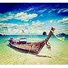 Vintage retro effect filtered hipster style travel image of long tail boat on tropical beach, Krabi, Thailand
