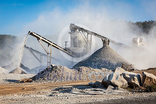 Industrial background - crusher rock stone crushing machine at open pit mining and processing plant for crushed stone, sand and gravel Industrial background - crusher rock stone crushing machine at open pit mining and processing plant for crushed stone, sand and gravel