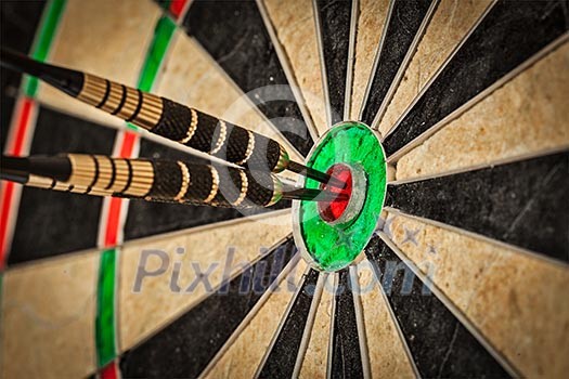 Success hitting target aim goal achievement concept background - three darts in bull's eye close up Success hitting target aim goal achievement concept background - three darts in bull's eye close up