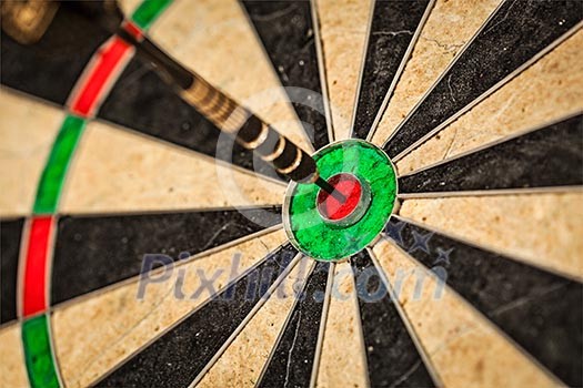 Success hitting target aim goal achievement concept background - dart in bull's eye close up Success hitting target aim goal achievement concept background - dart in bull's eye close up