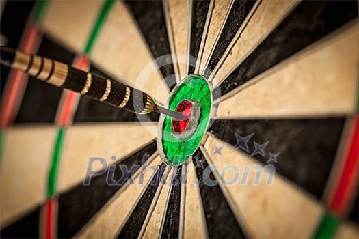 Success hitting target aim goal achievement concept background - dart in bull's eye close up Success hitting target aim goal achievement concept background - dart in bull's eye close up