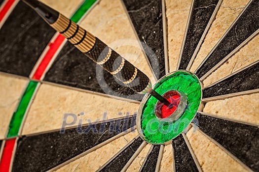 Success hitting target aim goal achievement concept background - dart in bull's eye close up Success hitting target aim goal achievement concept background - dart in bull's eye close up