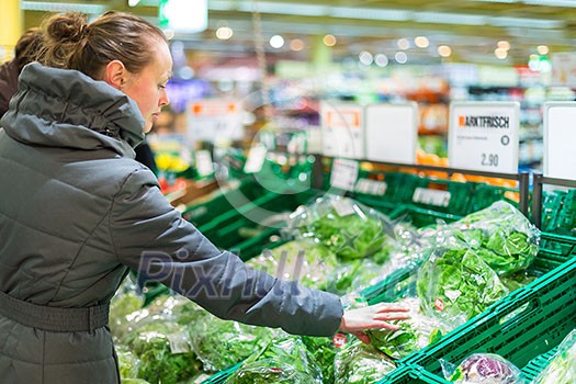 Beautiful, young woman shopping for fruits and vegetables in produce department of a grocery store/supermarket (shallow DOF; color toned image) Beautiful, young woman shopping for fruits and vegetables in produce department of a grocery store/supermarket (shallow DOF; color toned image)