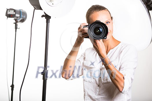 Pretty, female photographer with digital camera - DSLR and a huge telephoto lens (color toned image; shallow DOF) Pretty, female photographer with digital camera - DSLR and a huge telephoto lens (color toned image; shallow DOF)