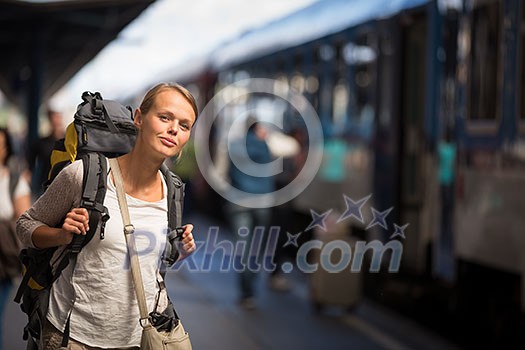 Pretty young woman boarding a train/having arrived to her destination, waiting for her friends to pick her up (color toned image) Pretty young woman boarding a train/having arrived to her destination, waiting for her friends to pick her up (color toned image)