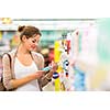 Beautiful young woman shopping in a grocery store/supermarket (color toned image)