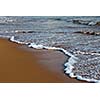 Wave surging on sand on beach