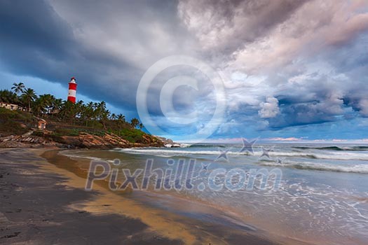 Gathering storm on beach and Kovalam (Vizhinjam) lighthouse on stormy sunset. Kerala, India Gathering storm on beach and Kovalam (Vizhinjam) lighthouse on stormy sunset. Kerala, India