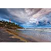 Gathering storm on beach and Kovalam (Vizhinjam) lighthouse on stormy sunset. Kerala, India