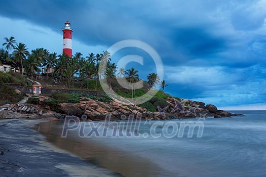 Gathering storm on beach and Kovalam (Vizhinjam) lighthouse on stormy sunset. Kerala, India Gathering storm on beach and Kovalam (Vizhinjam) lighthouse on stormy sunset. Kerala, India
