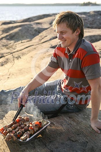 A man enjoying a barbecue by the sea A man enjoying a barbecue by the sea