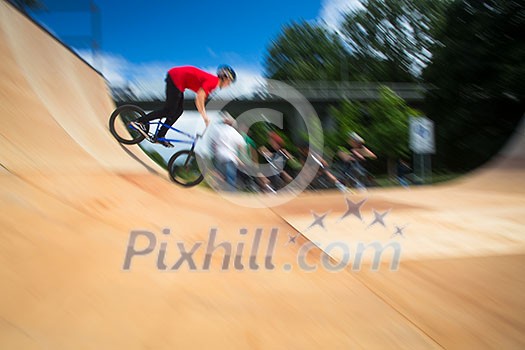 BMX Biker Performing Tricks during ride on a ramp BMX Biker Performing Tricks during ride on a ramp