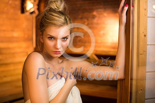 Young woman relaxing in a sauna, taking a break from her busy schedule, taking care of herself, enjoying the wellness benefits her job provides Young woman relaxing in a sauna, taking a break from her busy schedule, taking care of herself, enjoying the wellness benefits her job provides