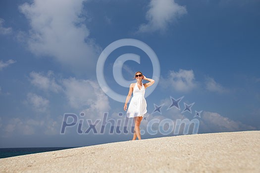 Pretty young woman outdoors, enjoying the sunlight and sea breeze while on vacation Pretty young woman outdoors, enjoying the sunlight and sea breeze while on vacation