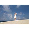 Pretty young woman outdoors, enjoying the sunlight and sea breeze while on vacation