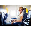 Pretty, young female passenger on board of an aircraft while on the flight