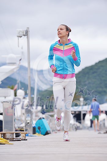 woman jogging at early morning with yacht boats in marina woman jogging at early morning with yacht boats in marina