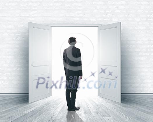 Image of businessman standing in front of opened door Image of businessman standing in front of opened door
