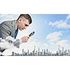 Image of businessman examining objects with magnifier