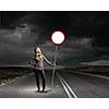 Young woman in casual holding road sign