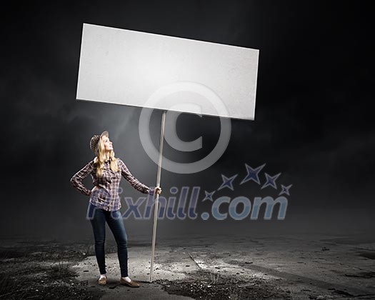 Young woman in casual carrying white blank banner Young woman in casual carrying white blank banner