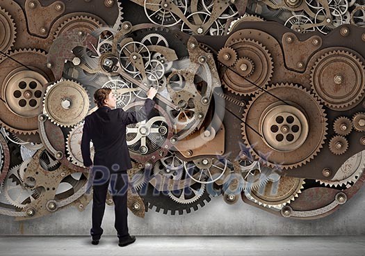 Young businessman fixing gears mechanism with wrench Young businessman fixing gears mechanism with wrench