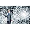 Young businessman with wrench against mechanism background