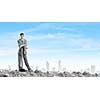 Young businessman with hammer standing on ruins