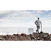 Young businessman with hammer standing on ruins