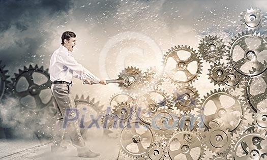 Young businessman fixing gears mechanism with wrench Young businessman fixing gears mechanism with wrench
