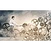 Young businessman fixing gears mechanism with wrench