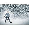 Young businessman with wrench against mechanism background
