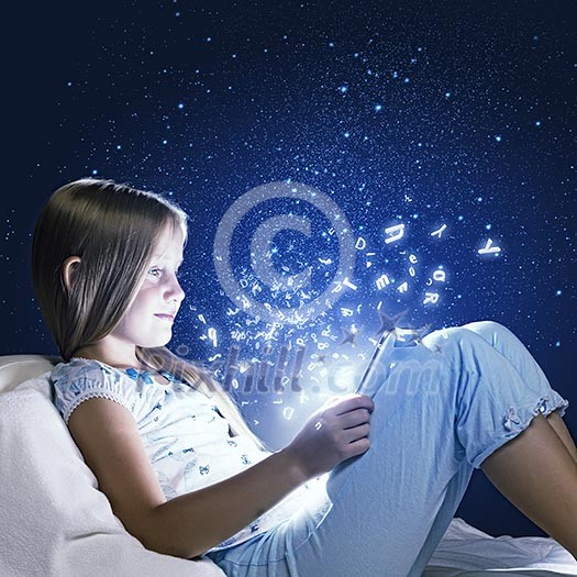 Girl sitting in bed and using tablet pc Girl sitting in bed and using tablet pc