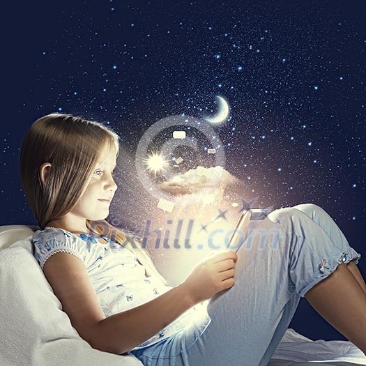 Girl sitting in bed and using tablet pc Girl sitting in bed and using tablet pc
