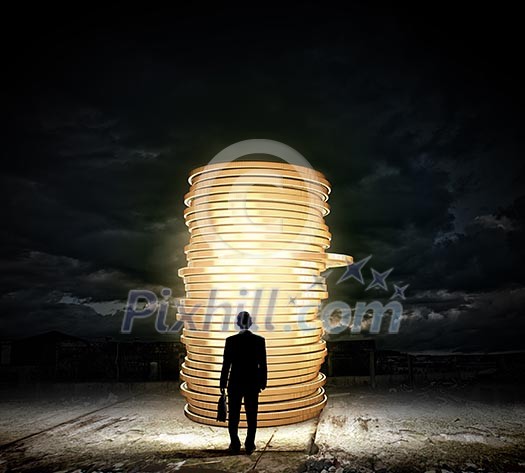 Rear view of businessman with suitcase looking at stack of coins Rear view of businessman with suitcase looking at stack of coins