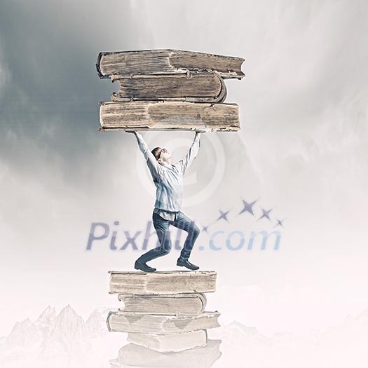 Young man holding huge book above head Young man holding huge book above head