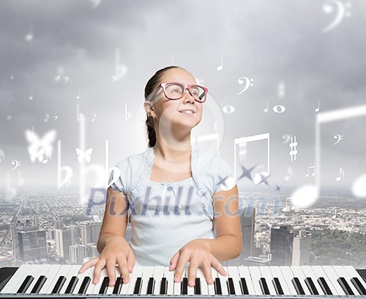 Young girl sitiing at digital piano with red glasses Young girl sitiing at digital piano with red glasses