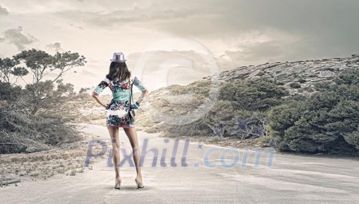 Rear view of young woman standing aside of road Rear view of young woman standing aside of road