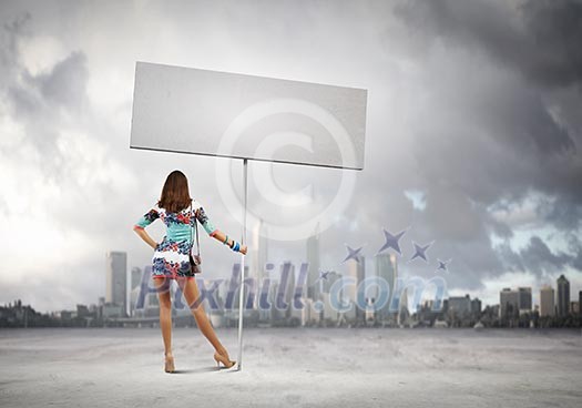 Rear view of young attractive woman with blank white banner Rear view of young attractive woman with blank white banner
