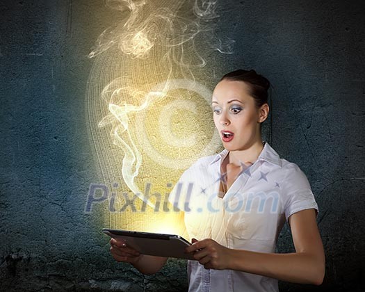 Young businesswoman looking astonished into tablet pc Young businesswoman looking astonished into tablet pc