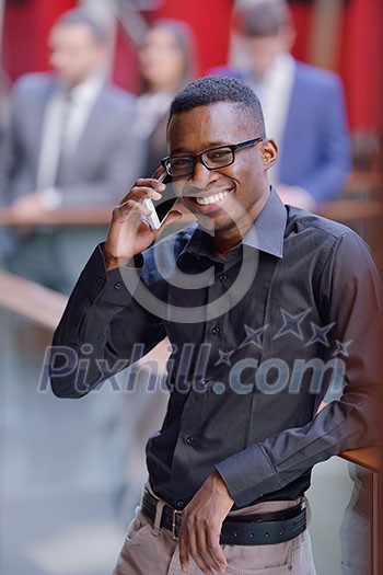Happy smiling successful African American businessman in a suit in a modern bright office indoors Happy smiling successful African American businessman in a suit in a modern bright office indoors