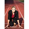 business woman in start position ready to run and sprint on athletics racing track