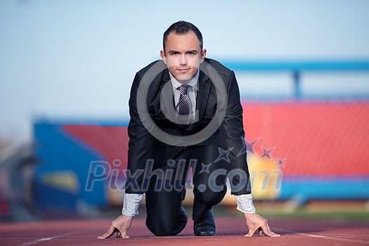 business man in start position ready to run and sprint on athletics racing track business man in start position ready to run and sprint on athletics racing track
