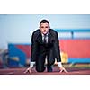 business man in start position ready to run and sprint on athletics racing track
