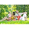 happy young couple with their children have fun at beautiful park outdoor in nature
