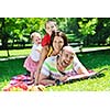 happy young couple with their children have fun at beautiful park outdoor in nature