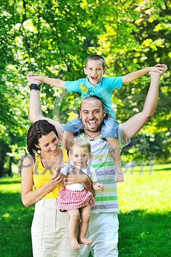 happy young couple with their children have fun at beautiful park outdoor in nature happy young couple with their children have fun at beautiful park outdoor in nature