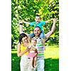 happy young couple with their children have fun at beautiful park outdoor in nature