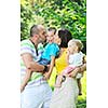 happy young couple with their children have fun at beautiful park outdoor in nature